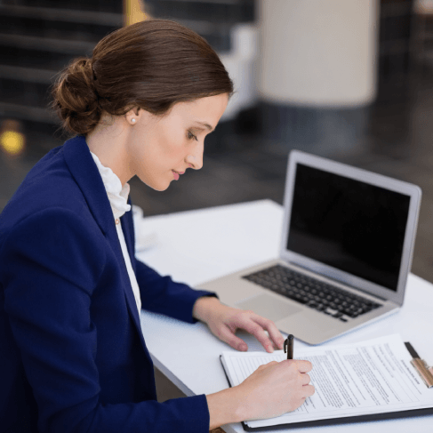 An ATA-certified linguist checks a stamped certificate at a Miami desk, delivering French Translation Services in Miami.