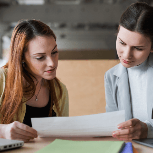 Two linguists review a translated diploma at home, relying on Russian Translation Services in Miami for corrections.