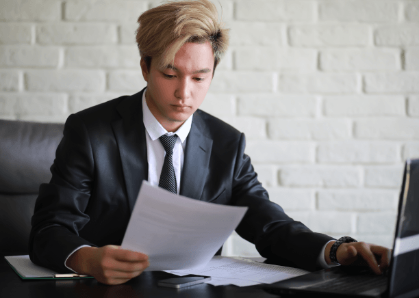 A translator formats a stamped birth certificate on a laptop, delivering Russian Translation Services in Miami for documents.